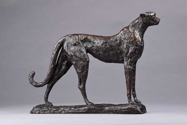 Bronze sculpture of a standing cheetah on a rectangular base with detailed texture.
